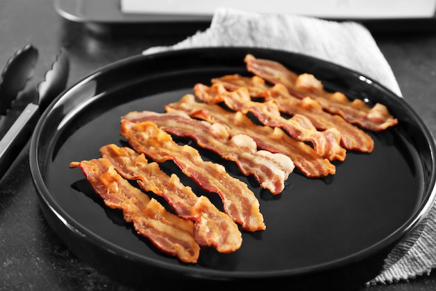 Tasty bacon slices on plate