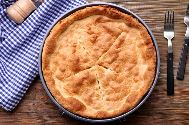 Tasty baked chicken pot pie on wooden table