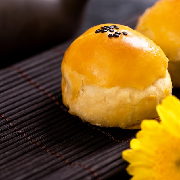 Tasty baked egg yolk pastry moon cake for MidAutumn Festival on black slate dark background Chinese festive food concept close up copy space