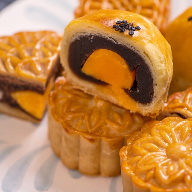 Tasty baked egg yolk pastry moon cake for MidAutumn Festival on black slate dark background Chinese festive food concept close up copy space