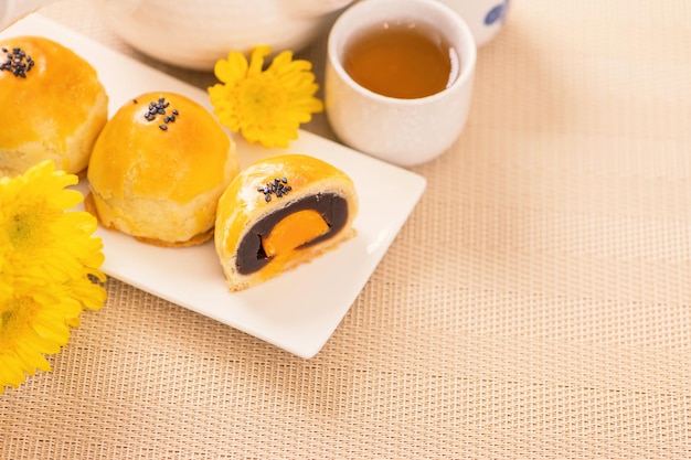 Tasty baked egg yolk pastry moon cake for midautumn festival on\
bright wooden table background chinese festive food concept close\
up copy space