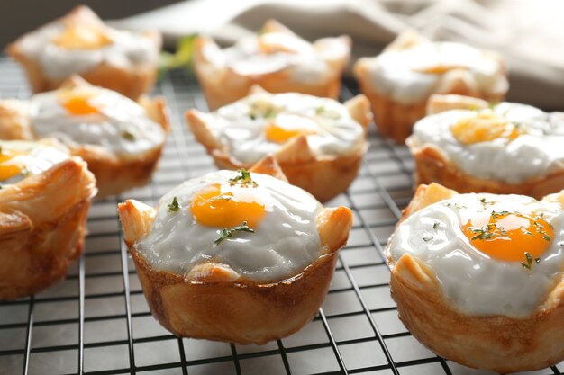 Tasty baked eggs in dough on cooling rack