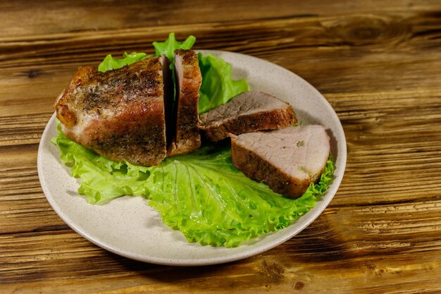 Tasty baked pork with spices on a wooden table