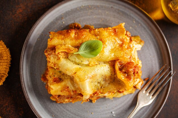 Tasty baked prepared classic italian lasagne in casserole on bright background. Closeup