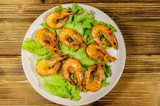 Tasty baked shrimps on a wooden table Top view