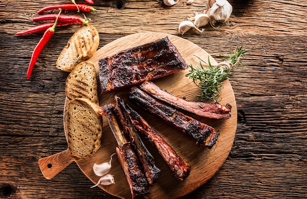 Tasty barbecue grilled pork ribs with chili pepers and parsley herbs.