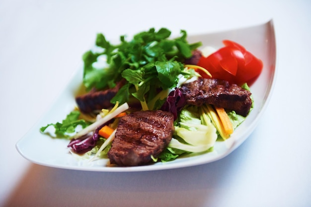 tasty bbq meat food, juicy beef steak with grilled cheese and salad in restaurant