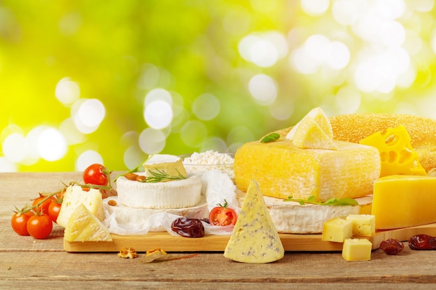 Tasty beautiful cheese composition on wooden board