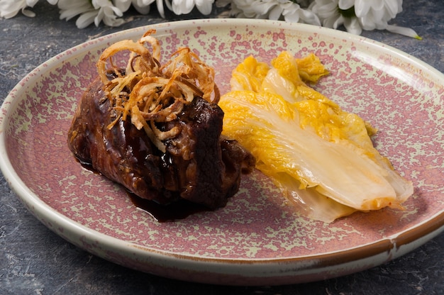 Tasty beef cheek with lettuce and fried onions