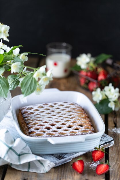 Tasty berry pie with strawberries on wooden table. Vertical