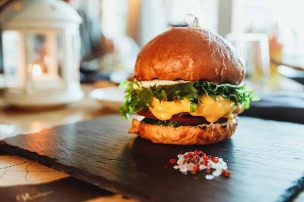 Gustoso hamburger doppio grasso americano con carne di maiale e carne di manzo e torta di pane al panino con salsa