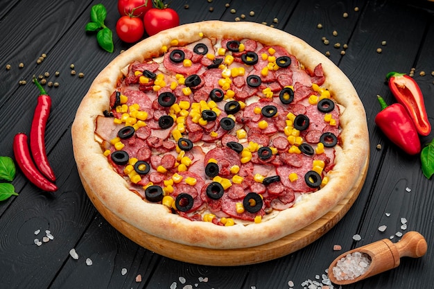 Tasty and big pizza with different types of meat Pizza with sausage ham corn and olives