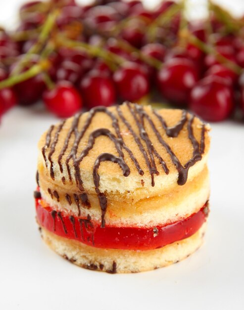 Tasty biscuit cake and berries isolated on white