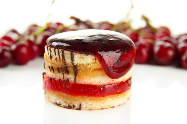 Tasty biscuit cake with jam and berries isolated on white