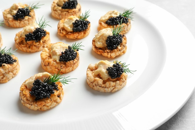 Tasty black caviar appetizer on plate