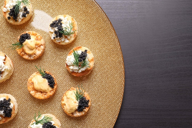 Tasty black caviar appetizers on plate