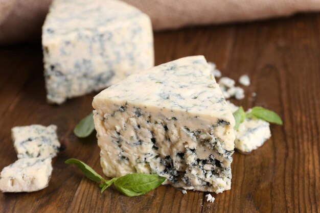 Foto saporito formaggio blu con basilico su un tavolo di legno