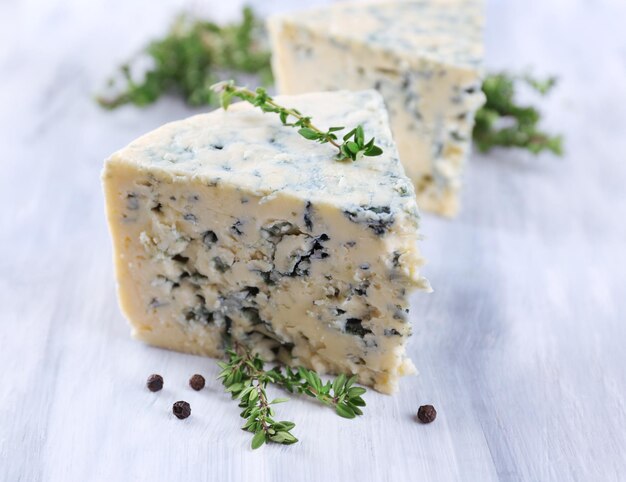 Tasty blue cheese with thyme and spices on wooden table