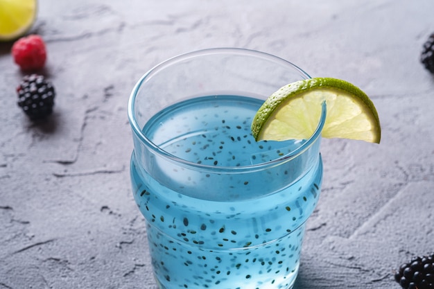 Tasty blue colored cocktail drink with basil chia seeds