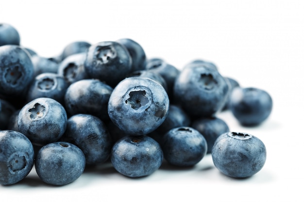 Tasty blueberries fruit are scattered on a white background