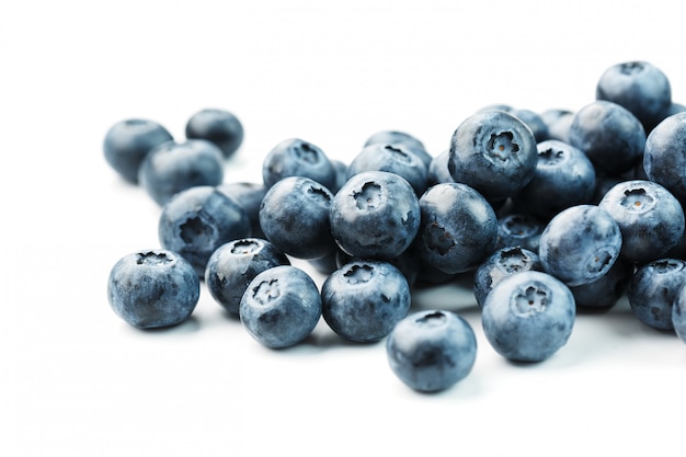 Tasty blueberries fruit are scattered on a white background