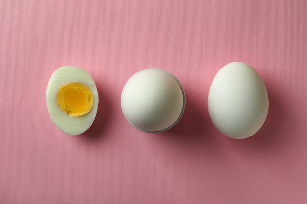 Tasty boiled eggs on pink