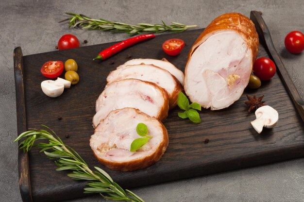 Photo tasty boiled smoked chicken rolls on a dark wooden board