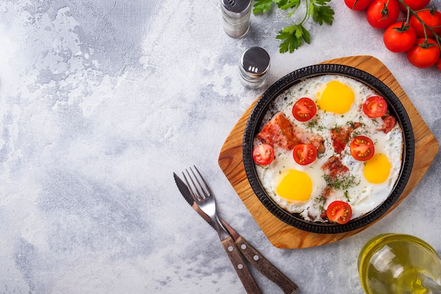 Tasty breakfast  fried eggs on a frying pan. Top view.