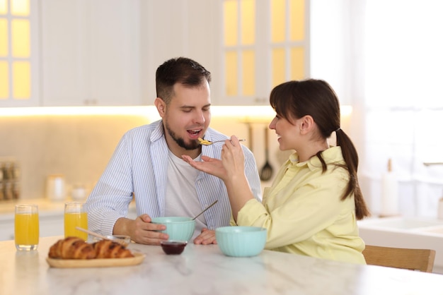 tasty breakfast happy wife feeding her husband at home