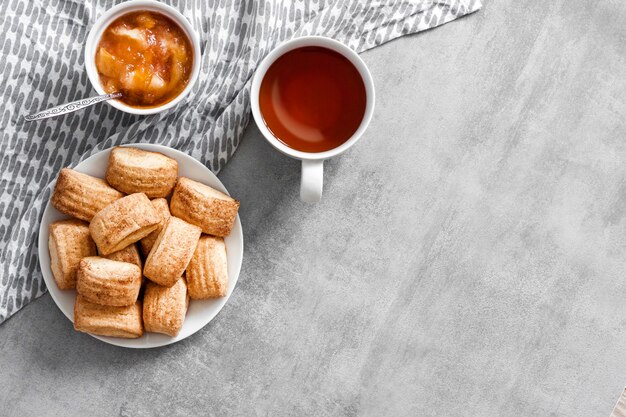 Gustosa colazione. biscotti dolci fatti in casa alla cannella, tazza di tè e confettura di mele. vista dall'alto