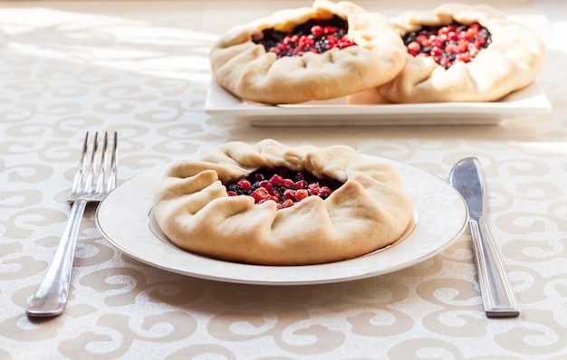 Tasty breakfast. Homemade sweet galette with elderberries and cowberries on a plate