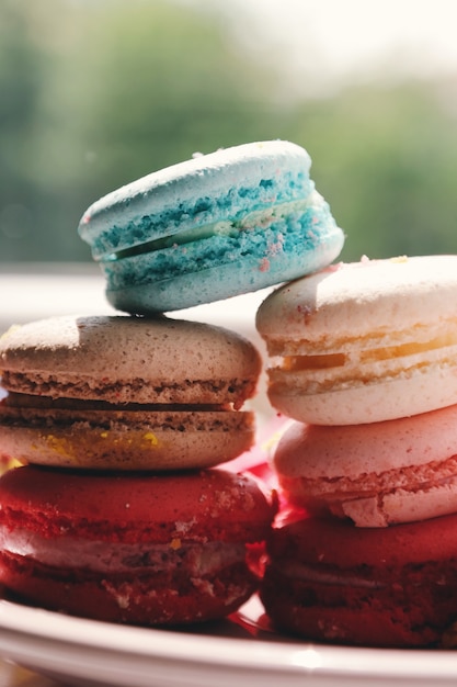 Tasty and bright macaroons lie on top of each other