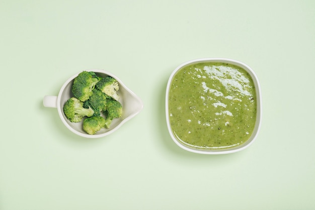 Tasty broccoli soup on a green background