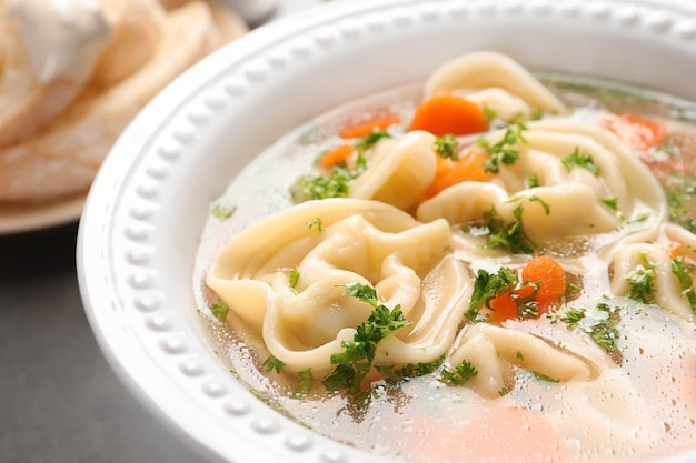 Tasty broth with dumplings closeup