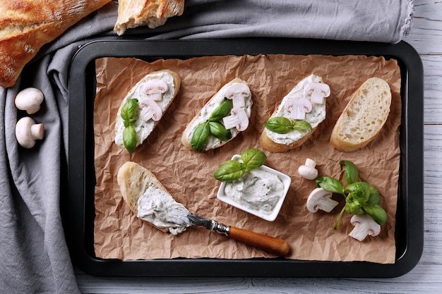 Tasty bruschetta with creamy cheese on baking tray