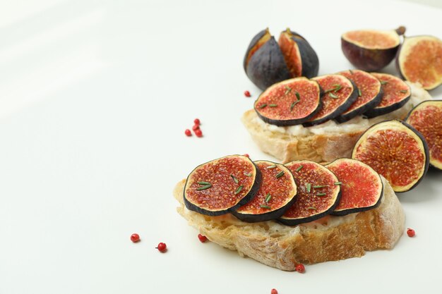 Tasty bruschetta with fig on white background