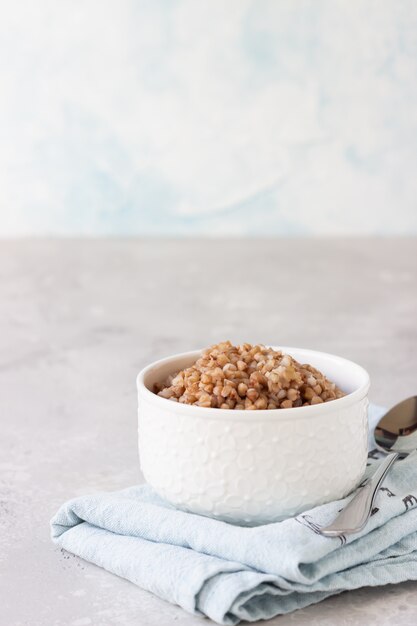 Tasty buckwheat porridge in a white ceramic bowl