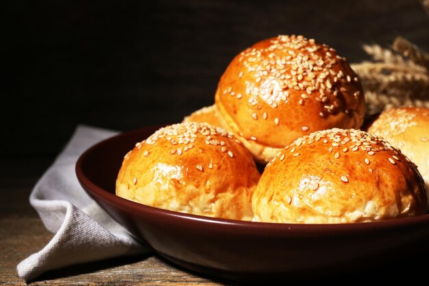 木製の背景に皿に胡麻のおいしいパン