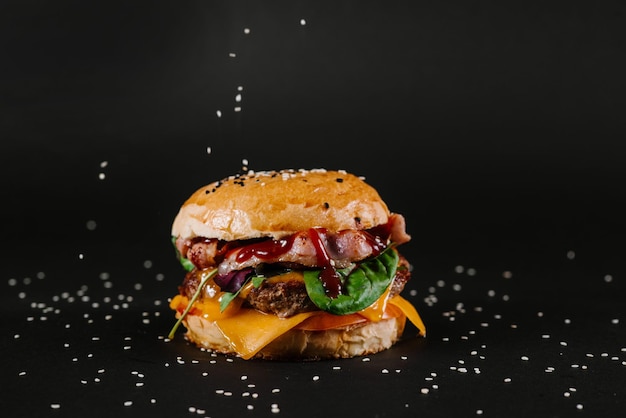 Tasty burger on the black background