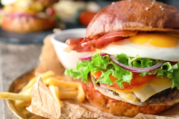 Tasty burger with fried egg on plate closeup