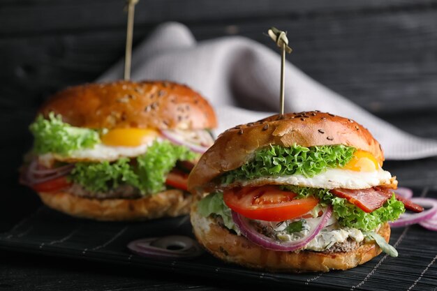 Tasty burger with fried egg on table closeup