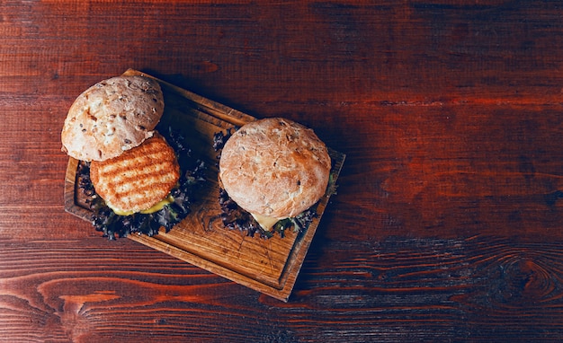 Tasty burger on wooden cutting board