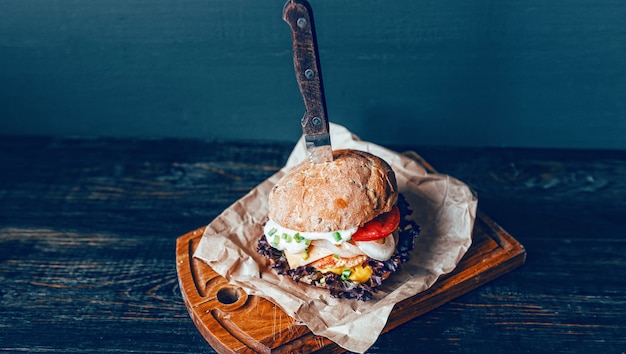 Вкусный гамбургер на деревянной разделочной доске