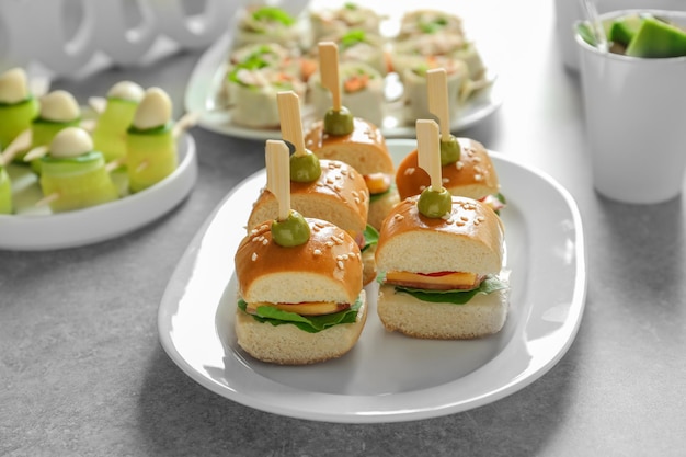 Tasty burgers for baby shower party on table