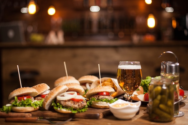 Tasty burgers with green salad on wooden table. Delicious burgers. Frenchs fries.