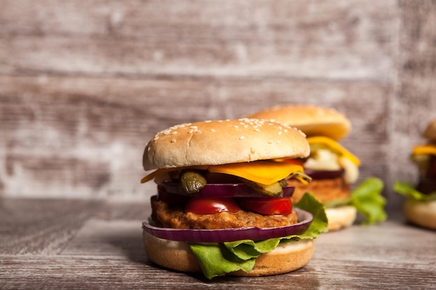 Tasty burgers on wooden background. Fast and tasty food