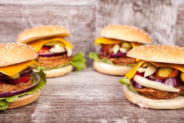 Tasty burgers on wooden background. Fast and tasty food