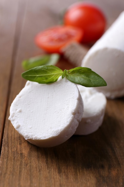 Foto formaggio bushe saporito con basilico e pomodoro sulla tavola di legno