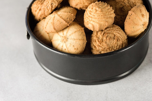 Gustosi biscotti al burro di latta su sfondo grigio set di biscotti di pasta frolla croccanti in un contenitore aperto