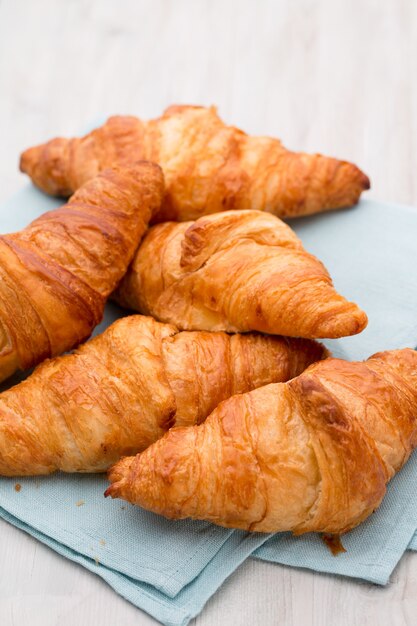 Tasty buttery croissants on old wooden table.